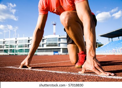 young muscular athlete is at the start of the treadmill at the stadium - Powered by Shutterstock