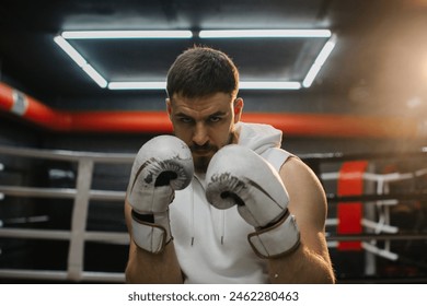 Young muscular boxer in boxing gloves looking at camera. - Powered by Shutterstock