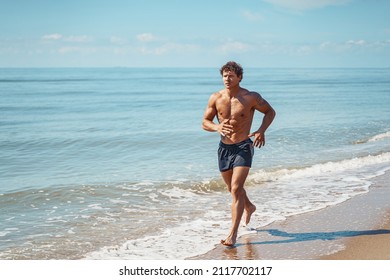 Young muscular guy, with a bare torso running along the beach. - Powered by Shutterstock