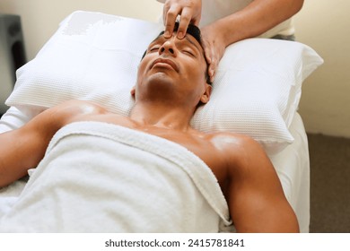 young muscular handsome man received acupressure facial massage from male therapist in spa. with the white towels and bed.  - Powered by Shutterstock