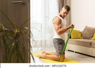 Young And Muscular Man During Home Workout With A Resistance Rubber Bands