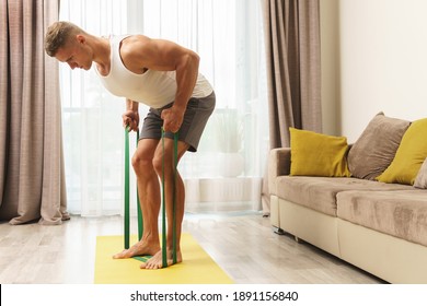 Young And Muscular Man During Home Workout With A Resistance Rubber Bands