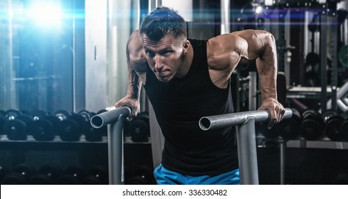 Young muscular man during workout in the gym