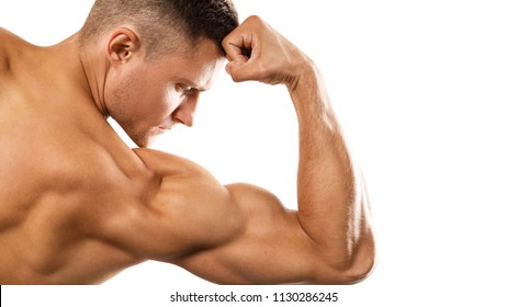 Young muscular man showing his bicep on white background - Powered by Shutterstock