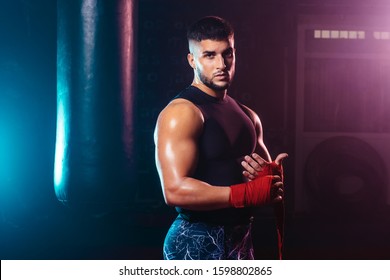 young and muscular man wrapping his hands with boxing hands tape - fight, sport and boxing themes - Powered by Shutterstock