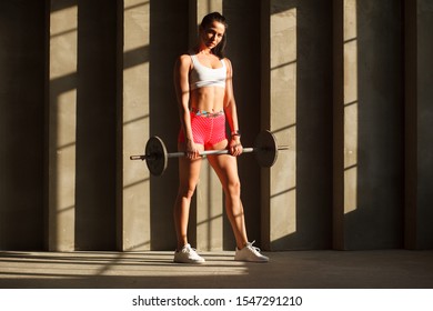 Young Muscular Woman Standing With Barbell In Gym, Ready To Sumo Dead Lift