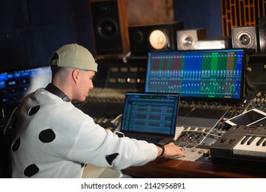 Young Music Producer Working In Sound Recording Studio. Sound Engineer Sitting At Laptop And Mixing Console Panel. Creating Music Concept