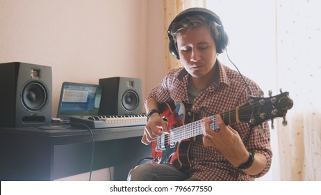 Young Musician Composes And Records Music Playing The Guitar Using Computer