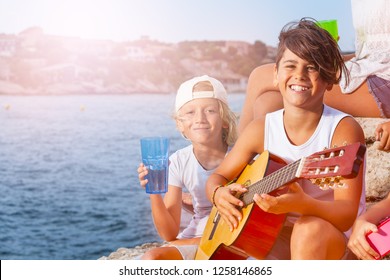 Young Musician Plays Guitar At Outing With Friends