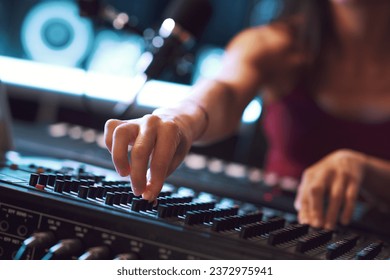 Young musician setting up the audio mixer in the recording studio, hands close up - Powered by Shutterstock