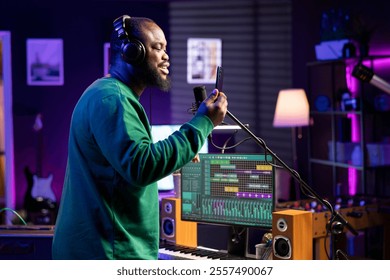 Young musician songwriter recording an acoustic version of his song, performing live on microphone in home studio. Skilled composer artist producing new tunes with creative lyrics. - Powered by Shutterstock