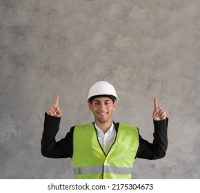 Young Muslim Architect Man Wearing Builder Safety Helmet Over Isolated Background Pointing Fingers Up. Exited And Happy. Empty Space For Your Advertisement