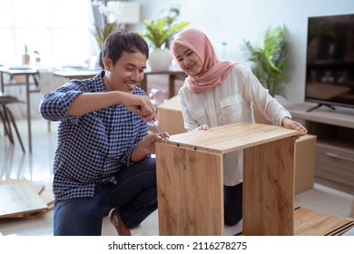 Young Muslim Couple Assembling Furniture At Home