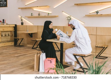 young muslim couple spending time in cafe after shopping