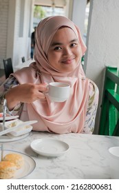 Young Muslim Woman Eating Delicious Scone With Strawberry Jam And Tea At The Strawberry Farm