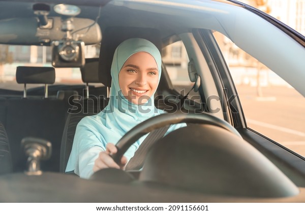 Young Muslim woman in modern\
car