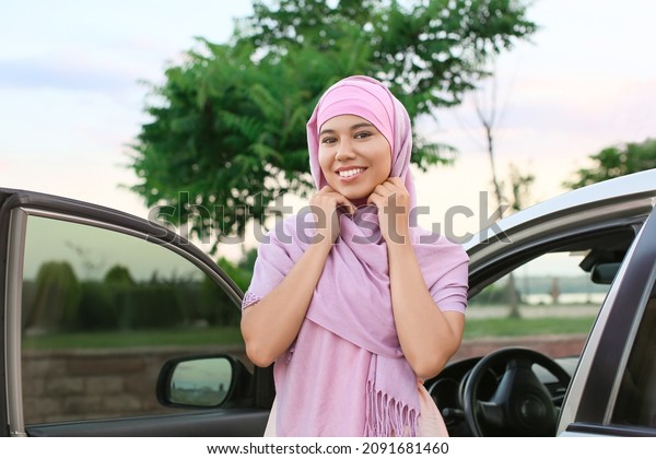 Young Muslim woman near\
car