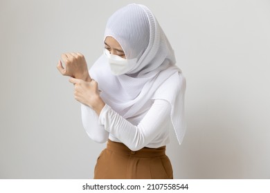 Young Muslim Woman Patient With Face Mask Holding Wrist Or Hand With Pain, Sickness Concept CTS, Wrist Pain, Trigger Finger, Bone Arthritis, Gout Symptoms, De Quervain's Disease