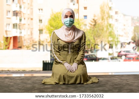 Young Muslim Woman Praying Outdoors Wearing Protective Mask and Gloves