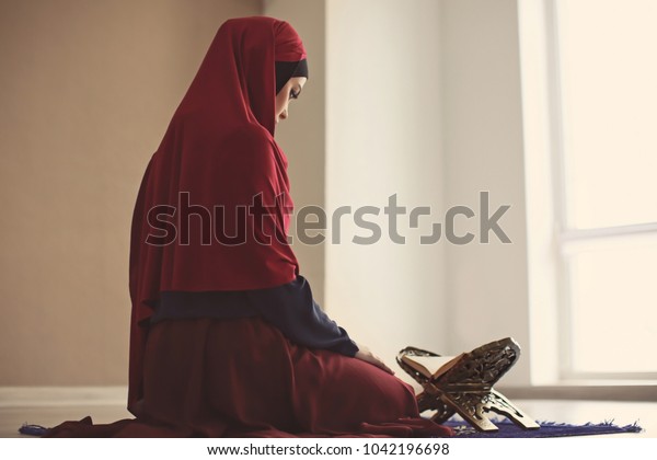 屋内でコーランを読む若いイスラム教徒の女性 の写真素材 今すぐ編集