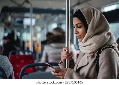 Young muslim woman with smartphone in public bus. - Powered by Shutterstock