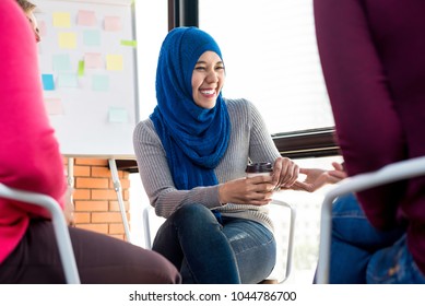 Young Muslim Woman Talking And Laughing With Her Friends Happily In Group Meeting