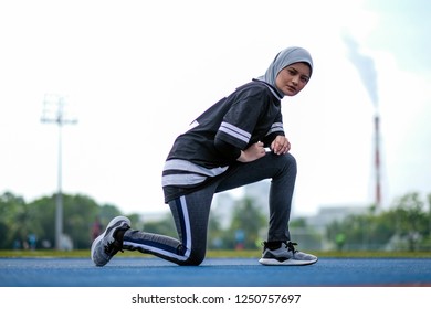 A Young Muslim Woman Wearing Hijab Exercising On Track At The Stadium