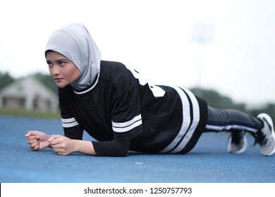 A Young Muslim Woman Wearing Hijab Exercising On Track At The Stadium