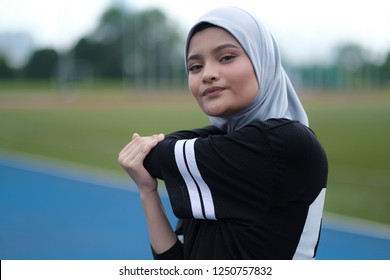 A Young Muslim Woman Wearing Hijab Exercising On Track At The Stadium