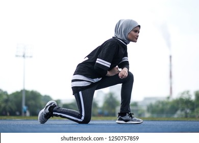 A Young Muslim Woman Wearing Hijab Exercising On Track At The Stadium