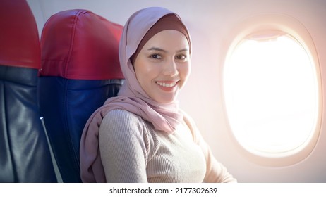 A Young Muslim Woman Wearing Hijab Using Smartphone Onboard, Travel And Holidays Concept