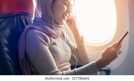 A Young Muslim Woman Wearing Hijab Using Smartphone Onboard, Travel And Holidays Concept