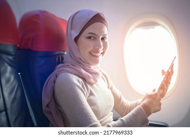 A Young Muslim Woman Wearing Hijab Using Smartphone Onboard, Travel And Holidays Concept