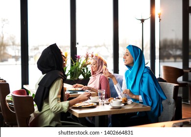 Young Muslim Women Eating In Cafe