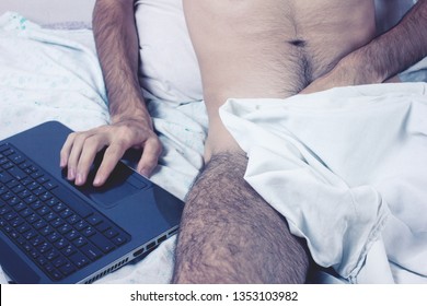 Young naked man watching pornography