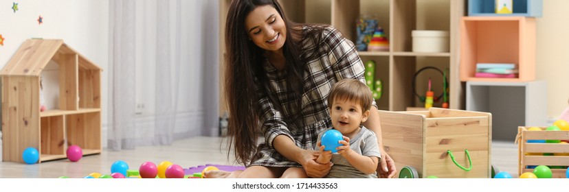 Young Nanny And Cute Little Baby Playing With Toys At Home. Banner Design 