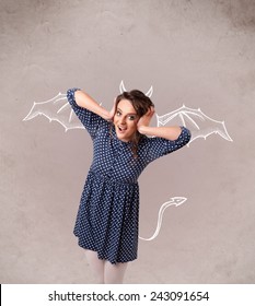 Young nasty girl with devil horns and wings drawing - Shutterstock ID 243091654