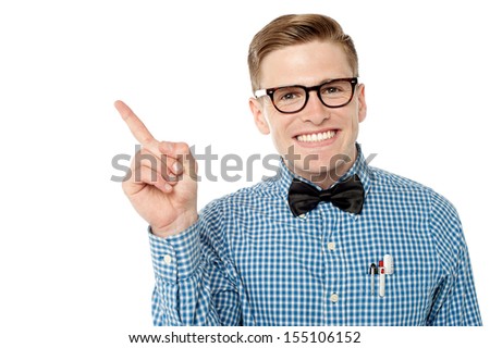 Young nerd pointing towards copy space area