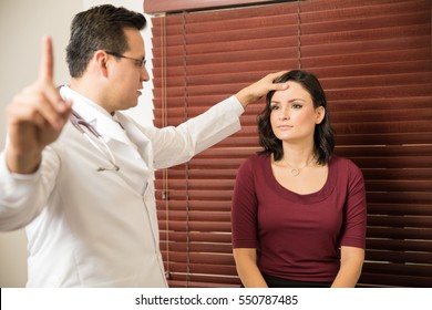 Young Neurologist Performing Some Neurological Tests On A Female Patient In An Office