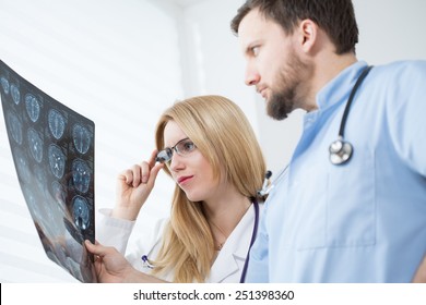 Young Neurologists Reading Brain MRI At Hospital