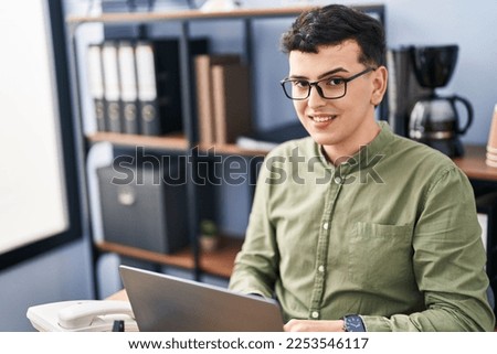 Young non binary man business worker using laptop working at office