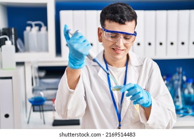 Young Non Binary Man Scientist Smiling Confident Using Pipette At Laboratory