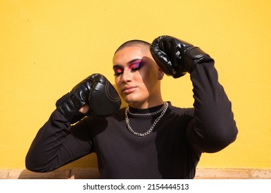Young non-binary person wears boxing gloves on a mustard yellow background, the person is make up and does different boxing poses. Concept equality, homosexuality, gay, lesbian, gay pride. - Shutterstock ID 2154444513