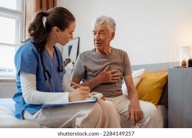 Young nurse checking elderly senior in his home. - Powered by Shutterstock