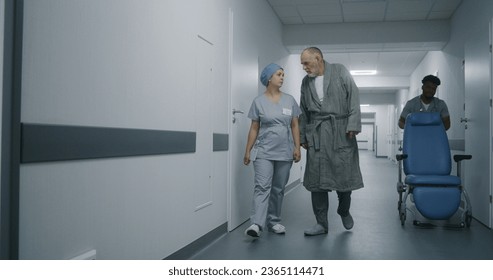 Young nurse with elderly patient walk down the hospital corridor and come into elevator. Nurse consults old patient about treatment. African American doctor goes to medical cabinet with wheelchair. - Powered by Shutterstock