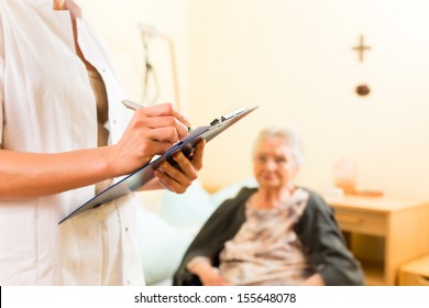 Young Nurse And Female Senior In Nursing Home, Measurements Are Taken Or Administrative Duties Taken Care Of