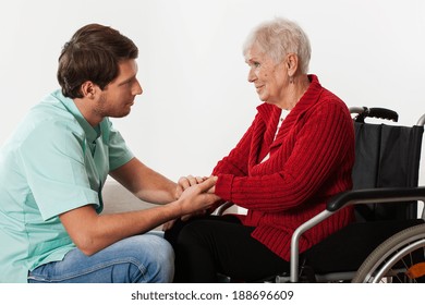 Young Nurse Full Of Compassion Assisting Lady On Wheelchair 