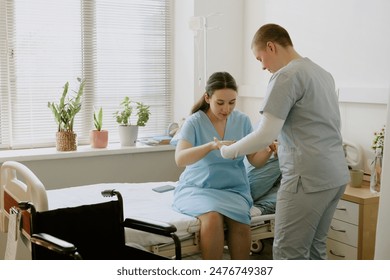 Young nurse helping pregnant patient with standing up while patient having contractions - Powered by Shutterstock