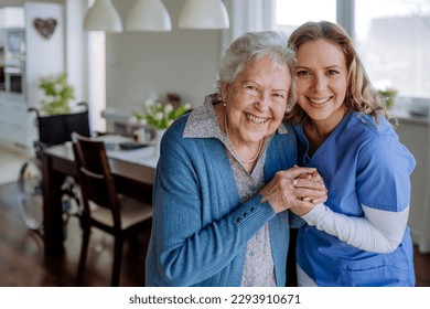 Young nurse hugging her senior woman client. - Powered by Shutterstock