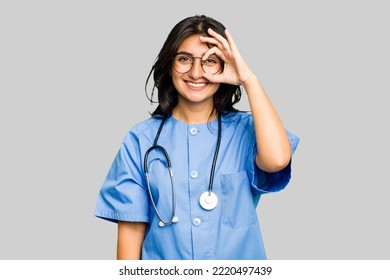 Young nurse Indian woman isolated excited keeping ok gesture on eye. - Powered by Shutterstock